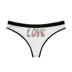 Ethereal shot, a white thong with colorful heart mosaic 'LOVE' text hanging on a thin black silk hanger, in front of a blowing sheer white curtain, soft focus, dreamy cinematic lighting.