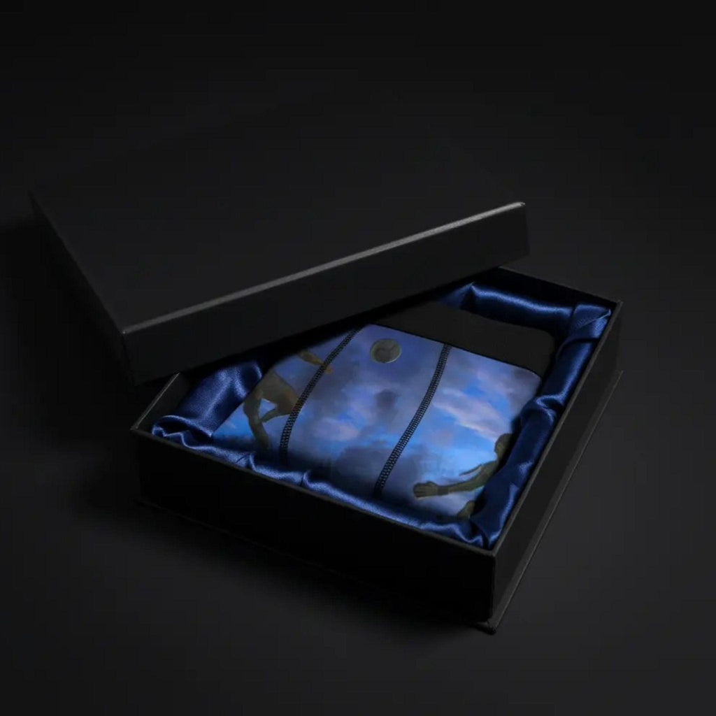 A premium matte black gift box opened to reveal the folded cinematic soccer boxer briefs inside, silk lining, luxury packaging aesthetic, moody studio lighting.