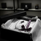 Luxury gift packaging, matte black box, white tissue paper, the boxer partially visible, elegant ribbon nearby, cinematic moody lighting, boutique gift shop style.