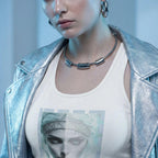 Close-up fashion shot, woman wearing the 'From Another Future' tank top paired with a silver metallic jacket. Focus on the graphic print and the texture of the fabric, futuristic jewelry, cool blue tones, high fashion magazine style.